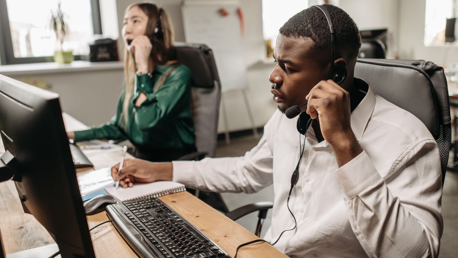 Une équipe concentrée de représentants du service client travaillant sur des ordinateurs et répondant à des appels dans un bureau