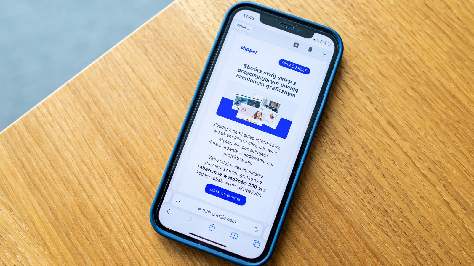 Smartphone affichant une publicité e-commerce sur une surface en bois, idéal pour des thèmes de marketing digital.